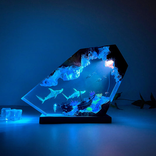 Decorative lamp with underwater scene and glowing blue light on a dark background